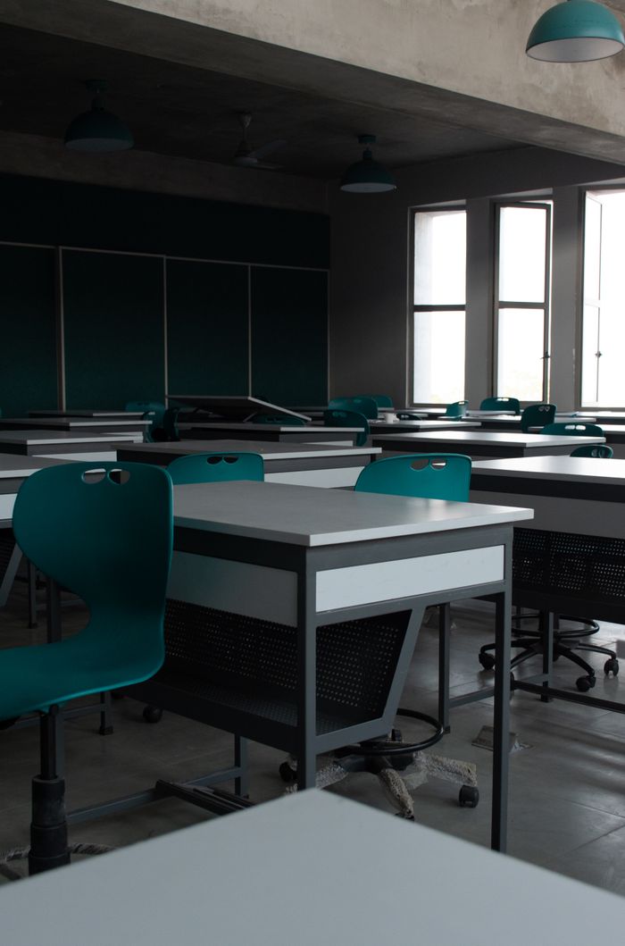 gallery-3 A contemporary classroom with empty desks and chairs, showcasing modern interior design.