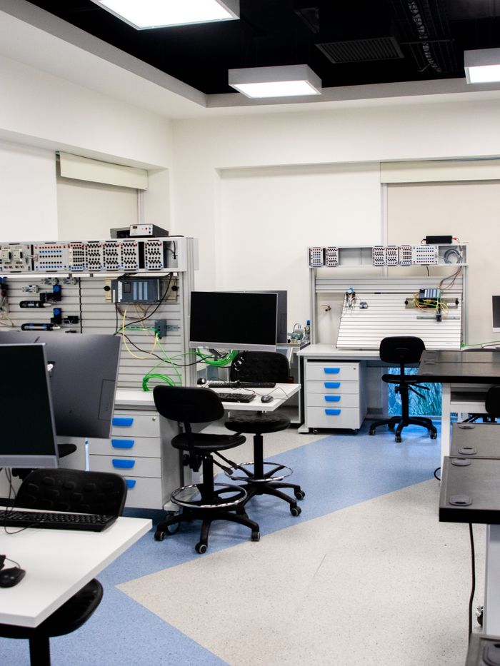 services-01 Bright and organized technology lab with computers and workstations, ideal for education or research.